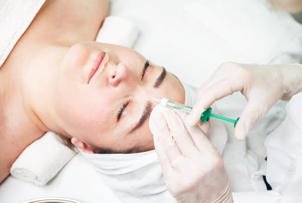 A woman receiving a facial injection from a professional, illustrating what are aesthetics treatments and how they help enhance skin appearance and rejuvenation.