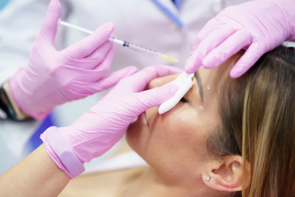 A woman receiving a gentle facial injection in a clinic setting, illustrating a common cosmetic treatment process related to botox after microneedling.